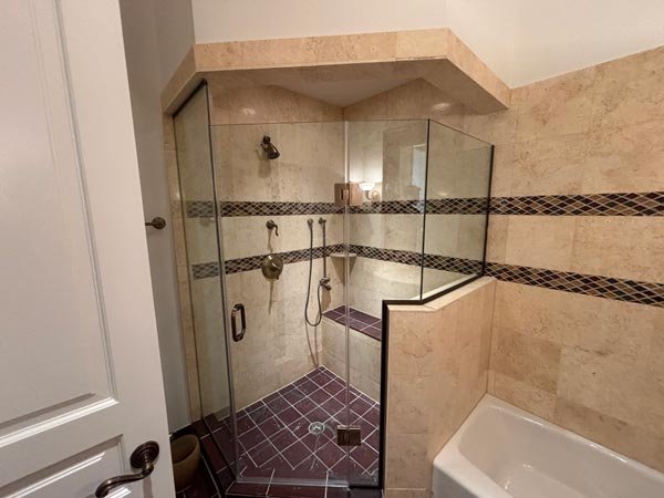 Frameless glass shower enclosure installed in a tiled bathroom