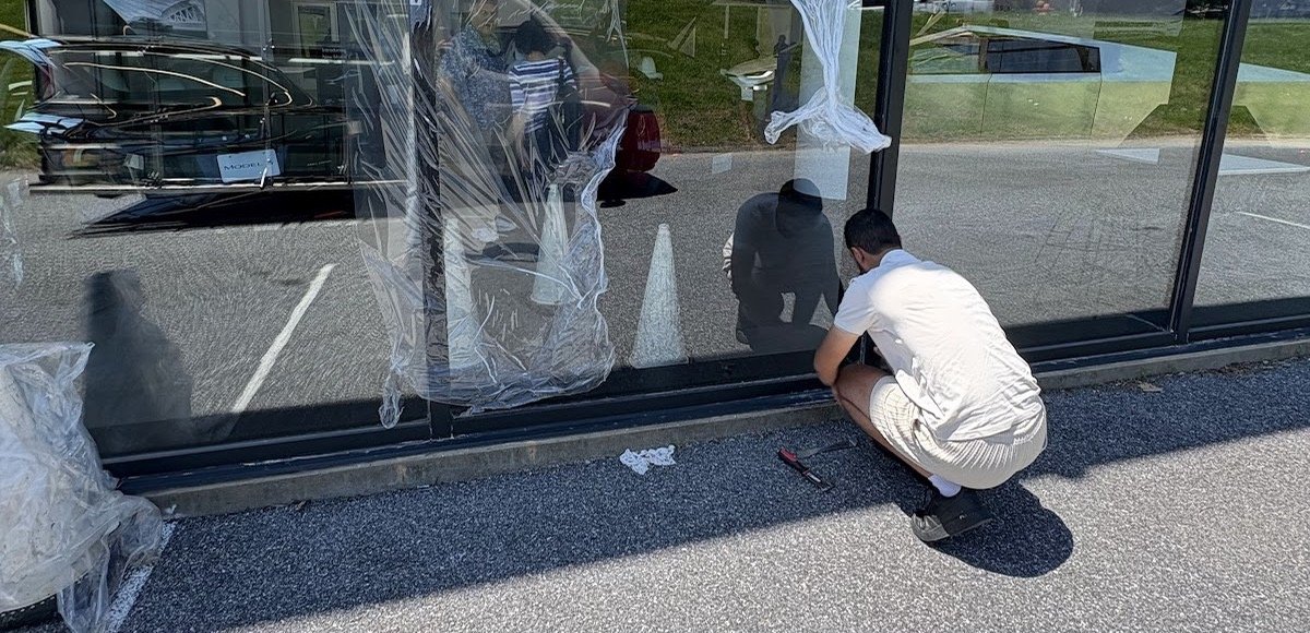 Prestine Glass technician fitting new storefront glass on a commercial building