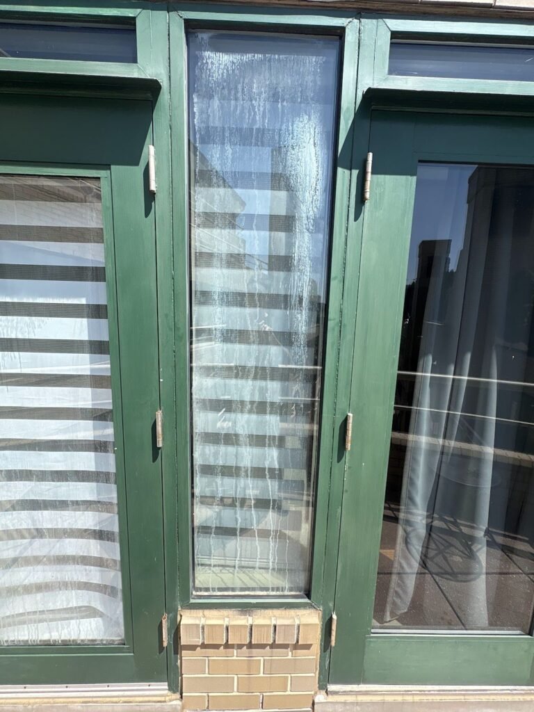 Cracked glass in a green storefront door frame