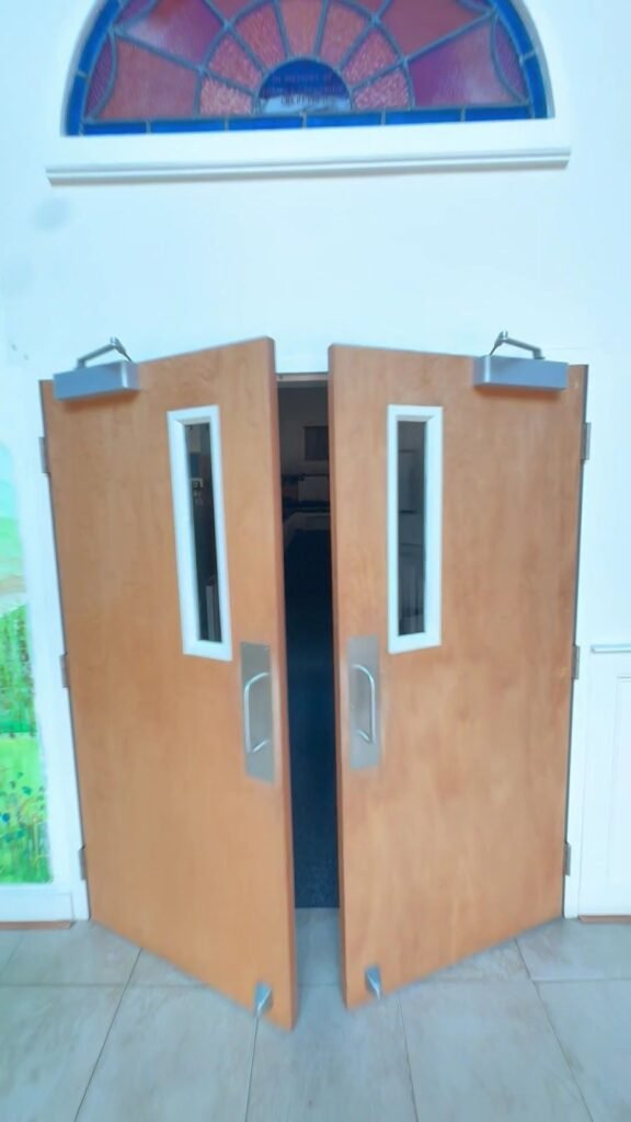 Wooden double doors with narrow glass vision panels