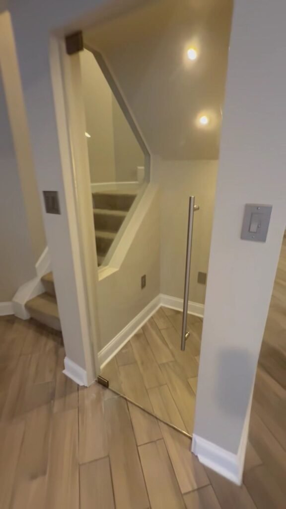 Frameless glass door enclosing a basement staircase