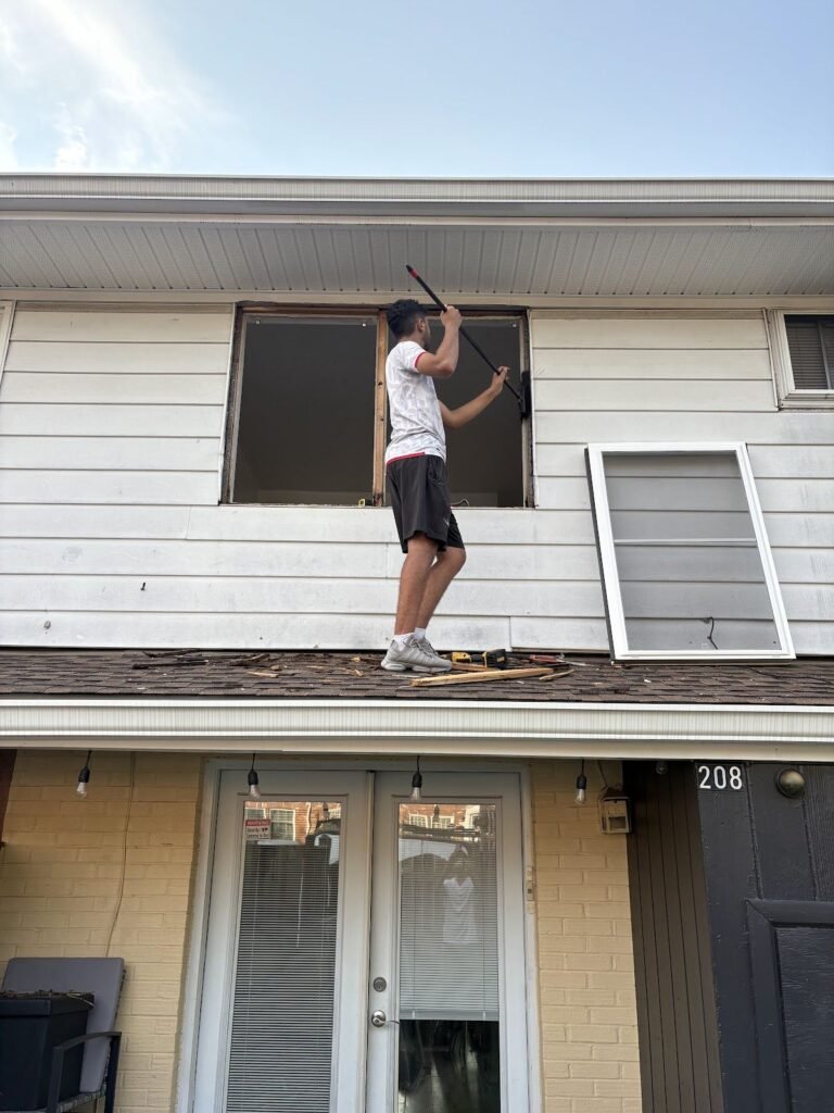 Technician replacing a second floor window from the porch roof