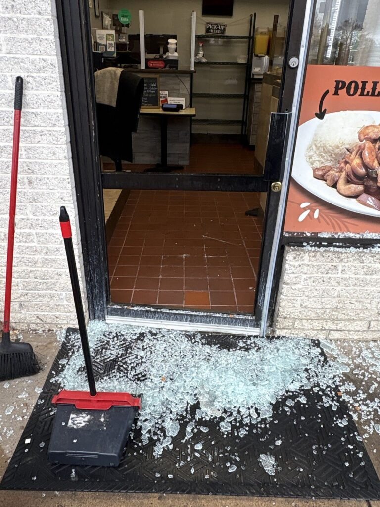 Broken glass from a shattered restaurant door being cleaned up